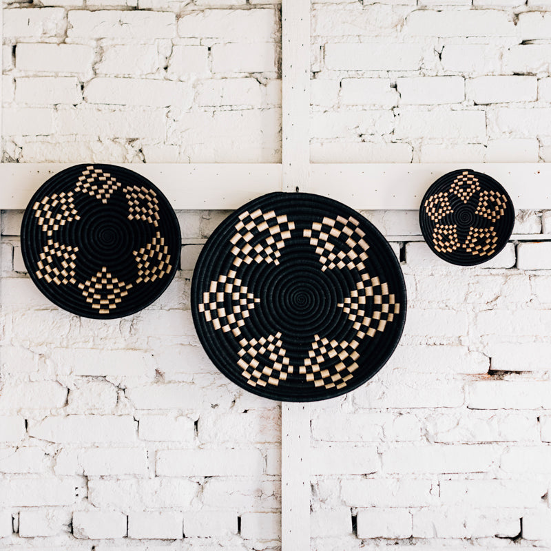 Set of Bariku woven bowls in black, tan, and cream sisal with handwoven patterns.