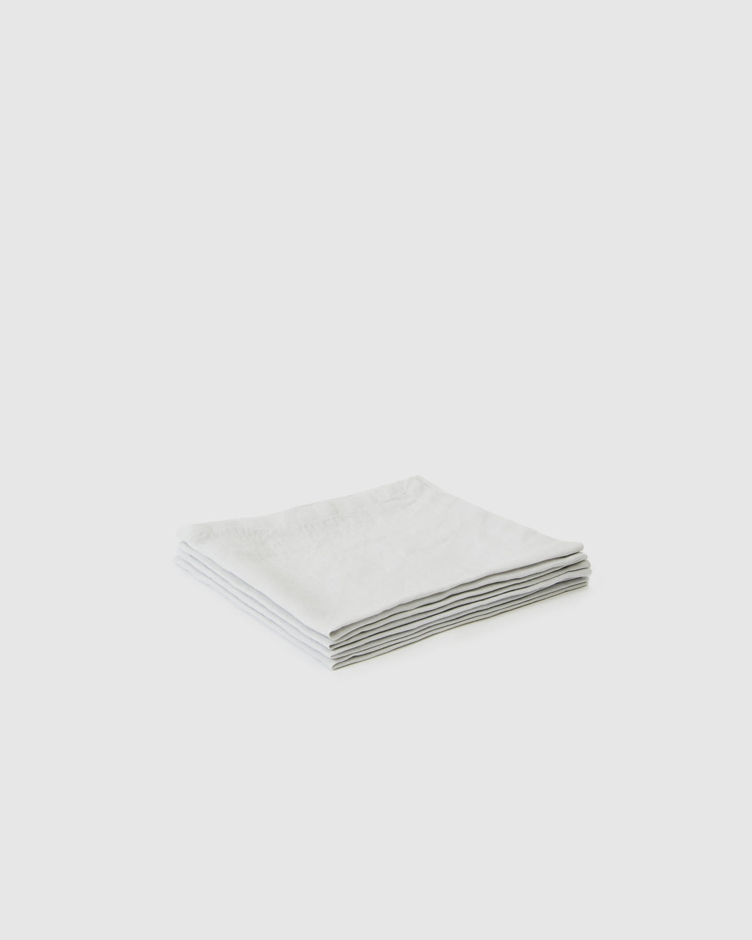 Set of glacier linen napkins folded on a dining table.