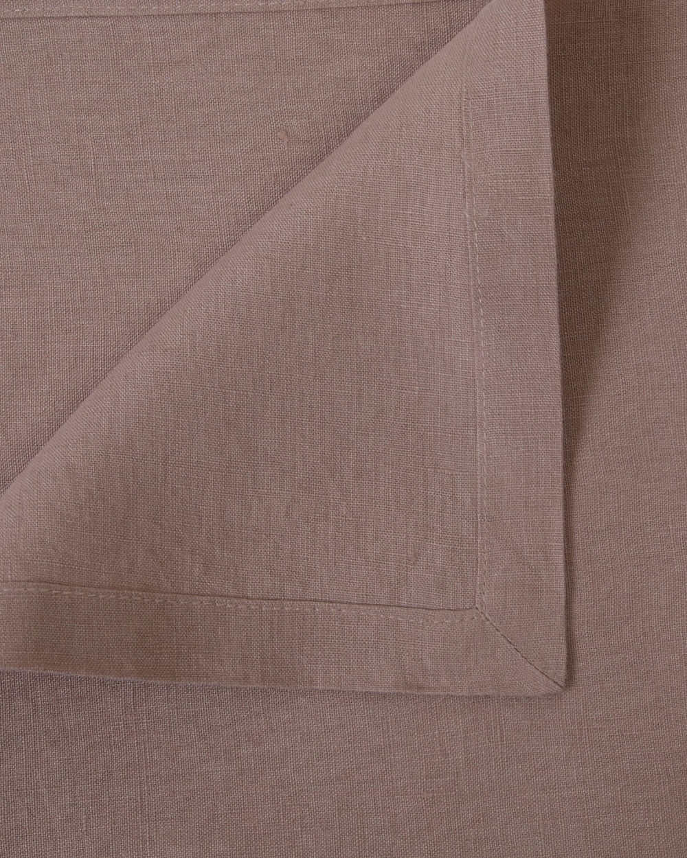 Close-up of four orchid linen napkins, showing fabric and hems.