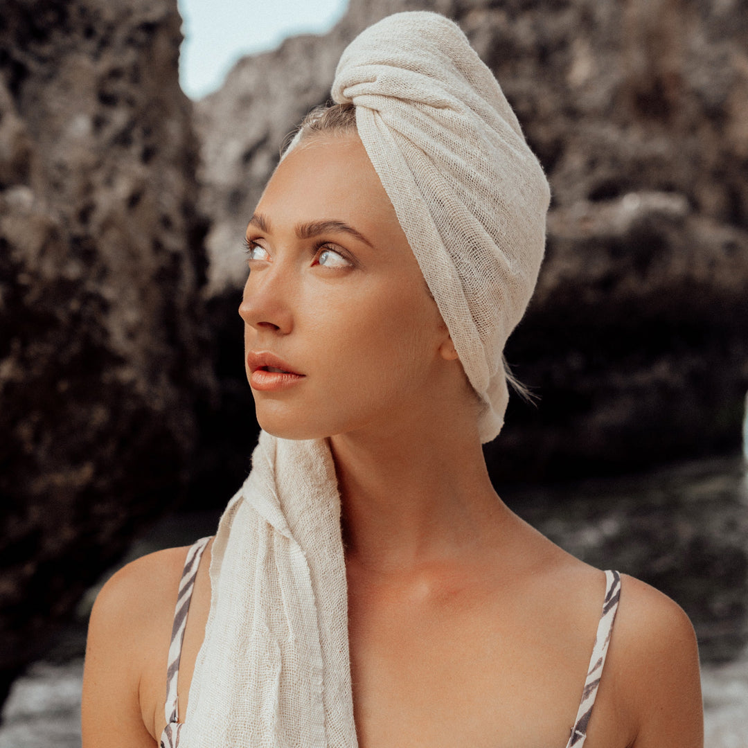 Hand-loomed cotton scarf in natural raw fiber, showing soft, breathable fabric and intricate weaving details.