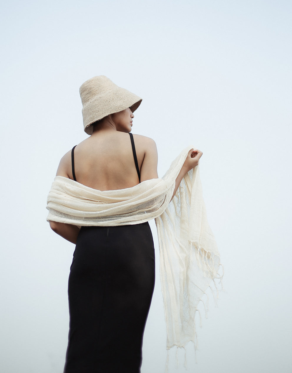 Hand-loomed cotton scarf in natural raw fiber, showing soft, lightweight fabric in a neutral white color.