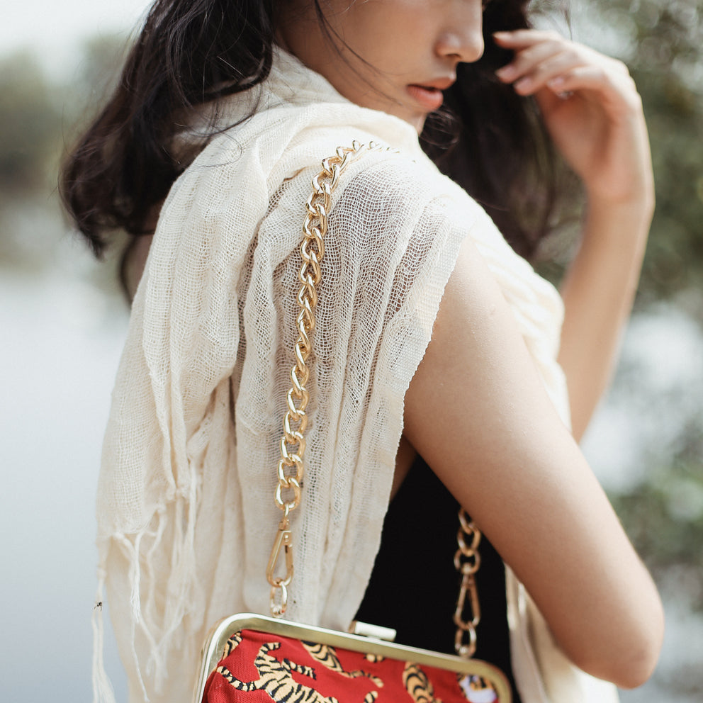 Hand-loomed cotton scarf in natural raw fiber, showing soft, woven fabric in a neutral white shade.