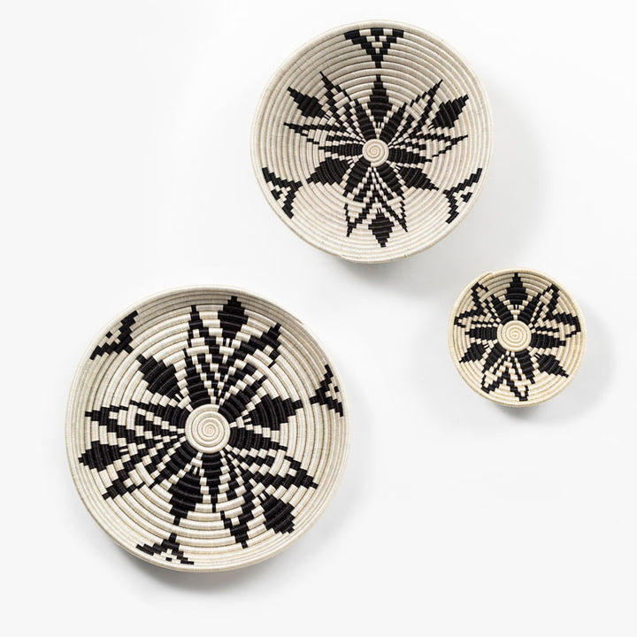 Set of Boutique Cactus Blossom woven bowls in cream and black with a radiating bloom pattern.