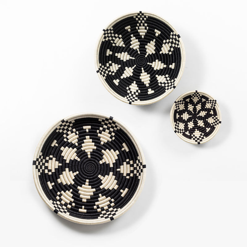 Set of Boutique Kaleidoscope woven bowls in black and natural sisal with a geometric pattern.