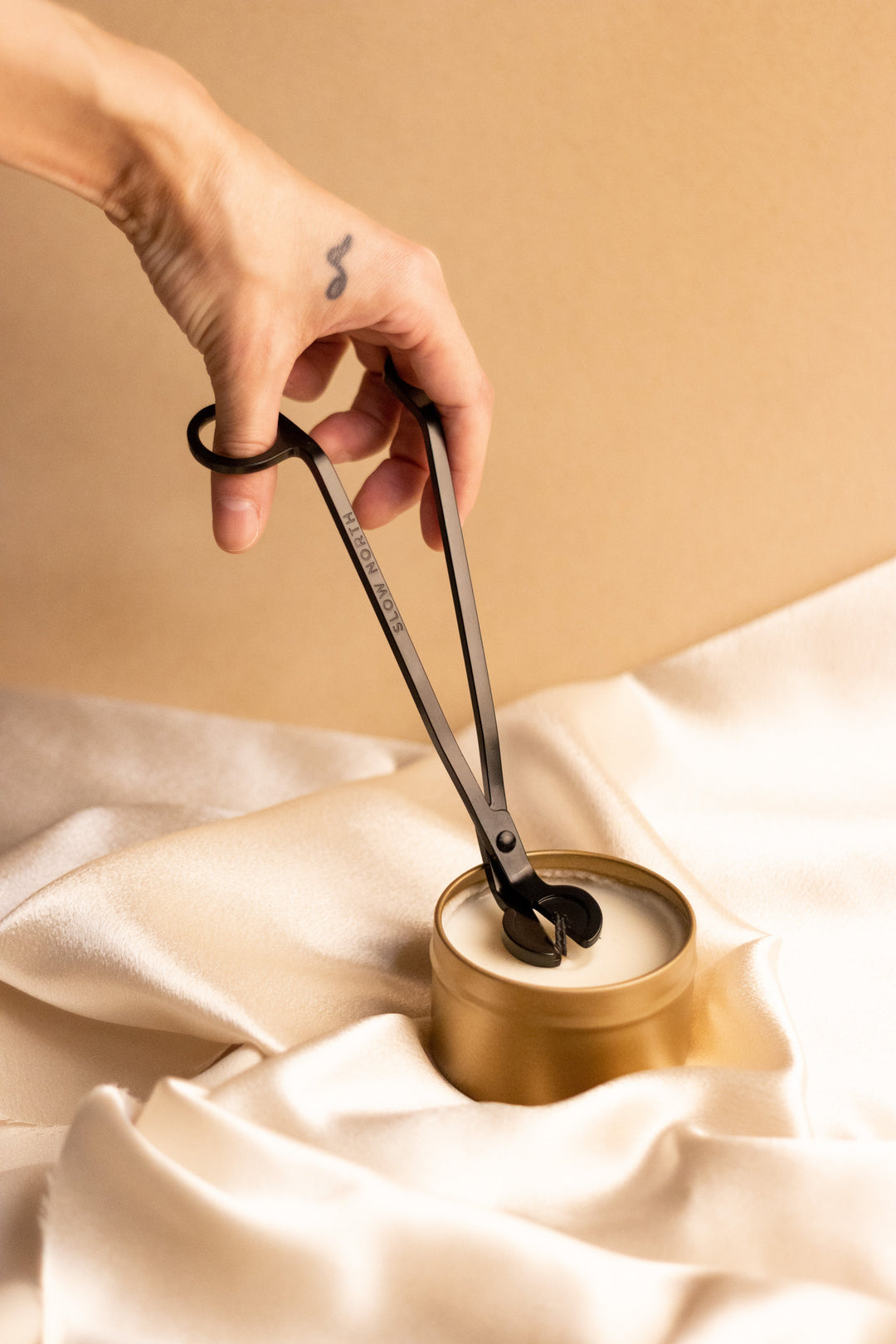 Black steel candle maintenance tools with cotton storage pouch.
