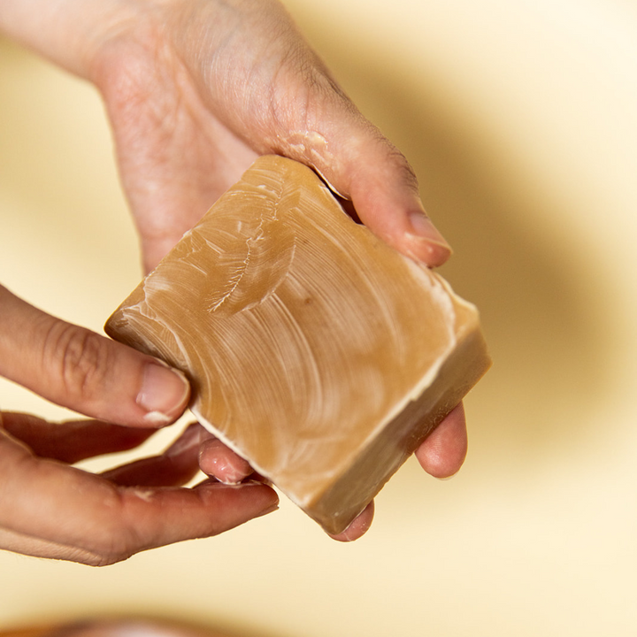 Coconut oatmeal soap bar displayed with branded label.