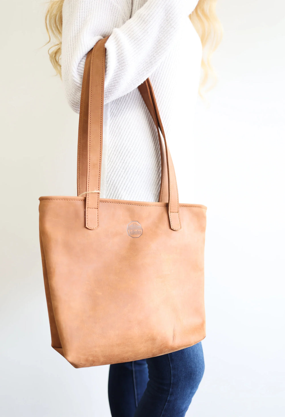 Handmade leather tote bag with shoulder straps and a spacious main compartment.