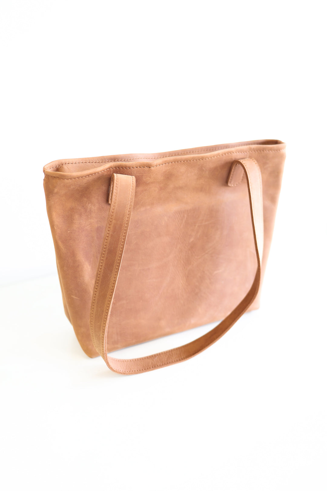 Small full-grain leather tote bag with sturdy handles and a roomy interior, handmade in Kenya.