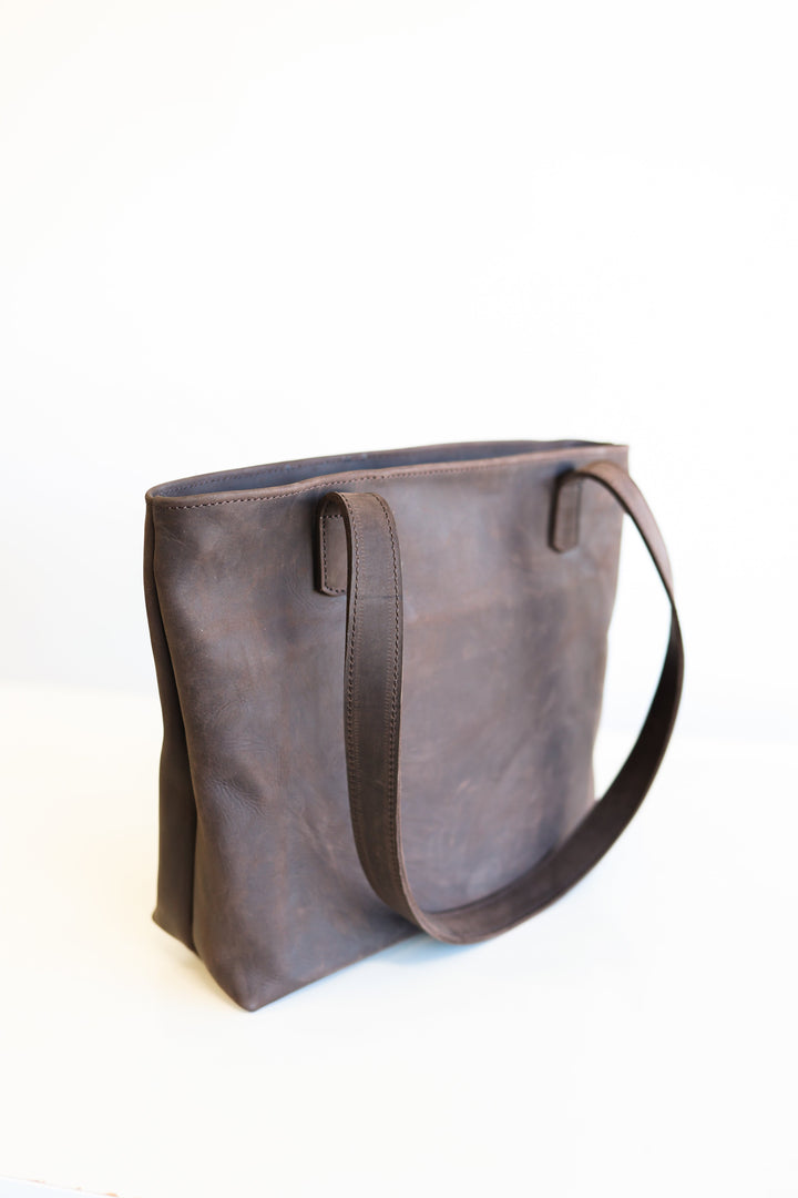 Handmade leather tote bag with sturdy handles and a roomy interior.