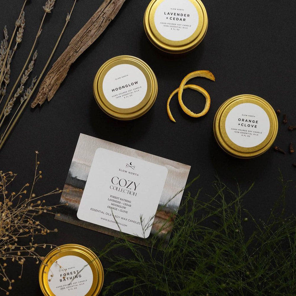 Cozy Collection four-pack of soy travel tin candles in a kraft gift box.