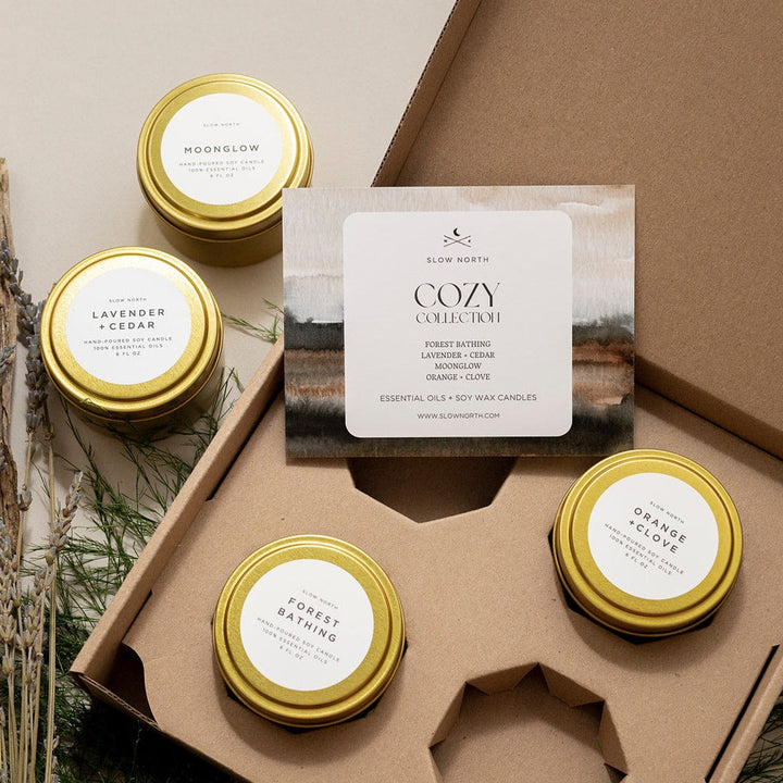 Cozy Collection gift set of four brushed gold travel tin candles in a kraft box.