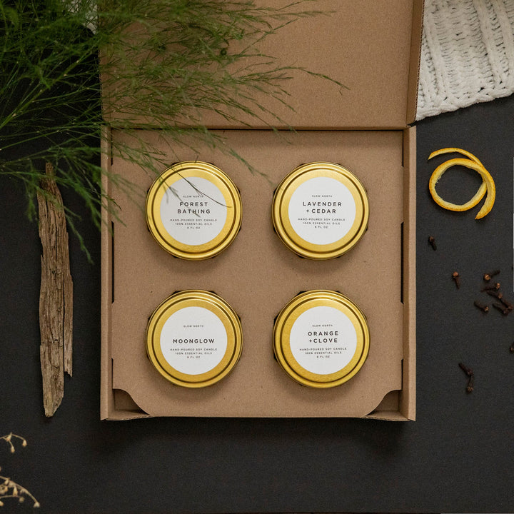 Cozy Collection set of four travel tin candles - Forest Bathing, Lavender and Cedar, Moonglow, and Orange and Clove.