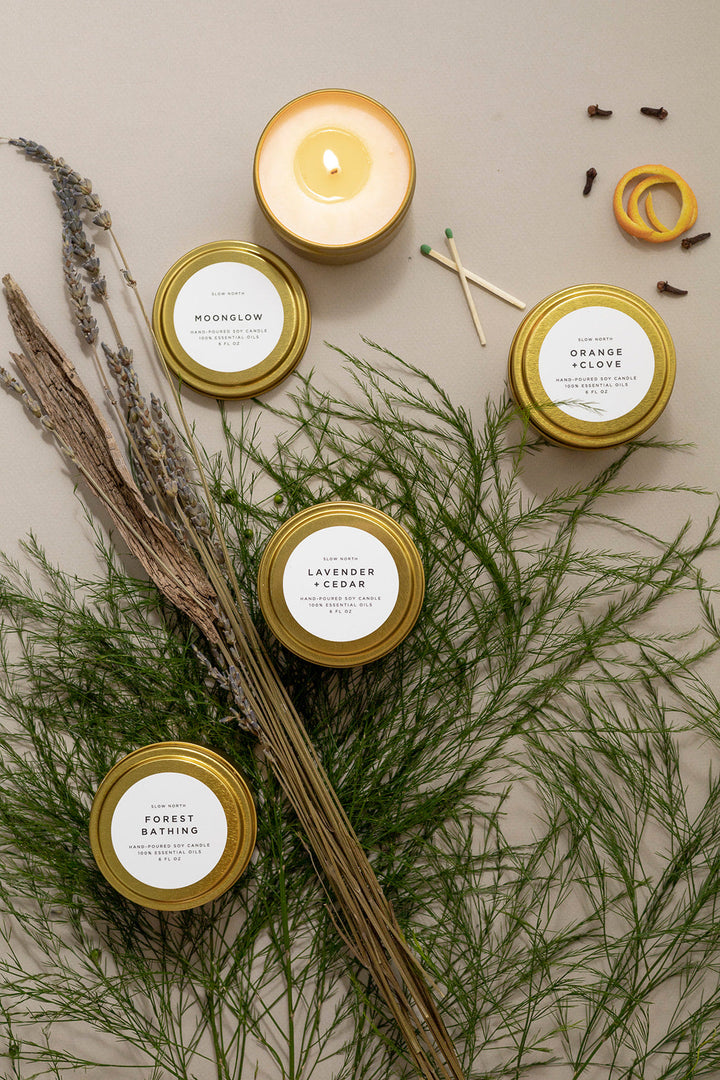 Cozy Collection gift set with four brushed gold tin candles and a scent card.