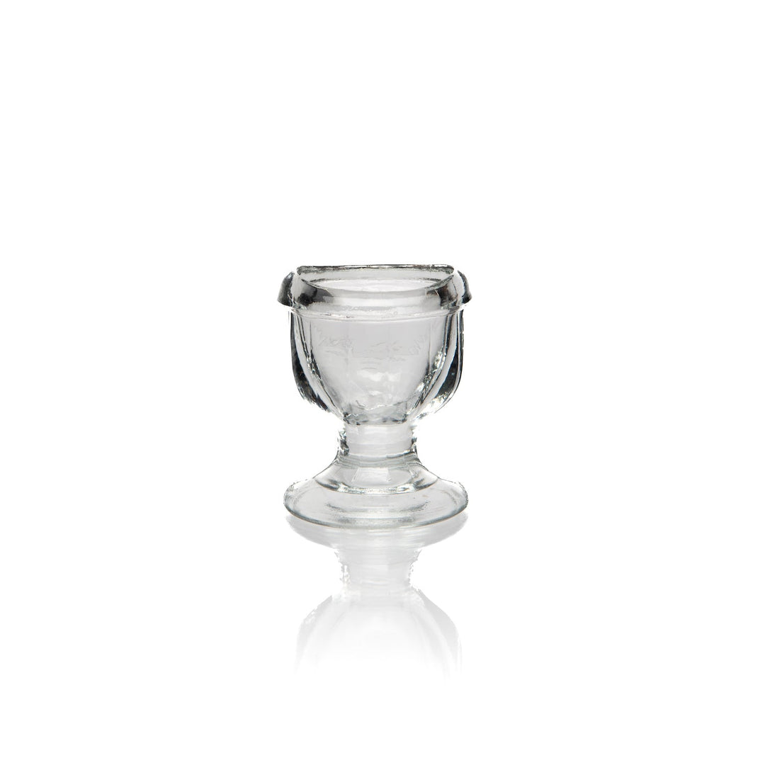 Glass eye wash cup shown filled with water.