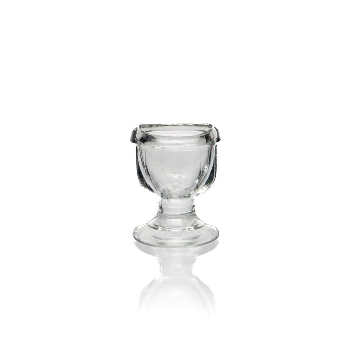 Glass eye wash cup shown filled with water.