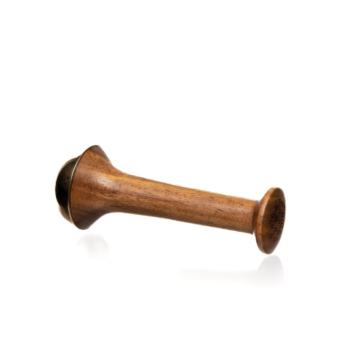 Kansa wand facial tool with a rounded metal end for facial massage.