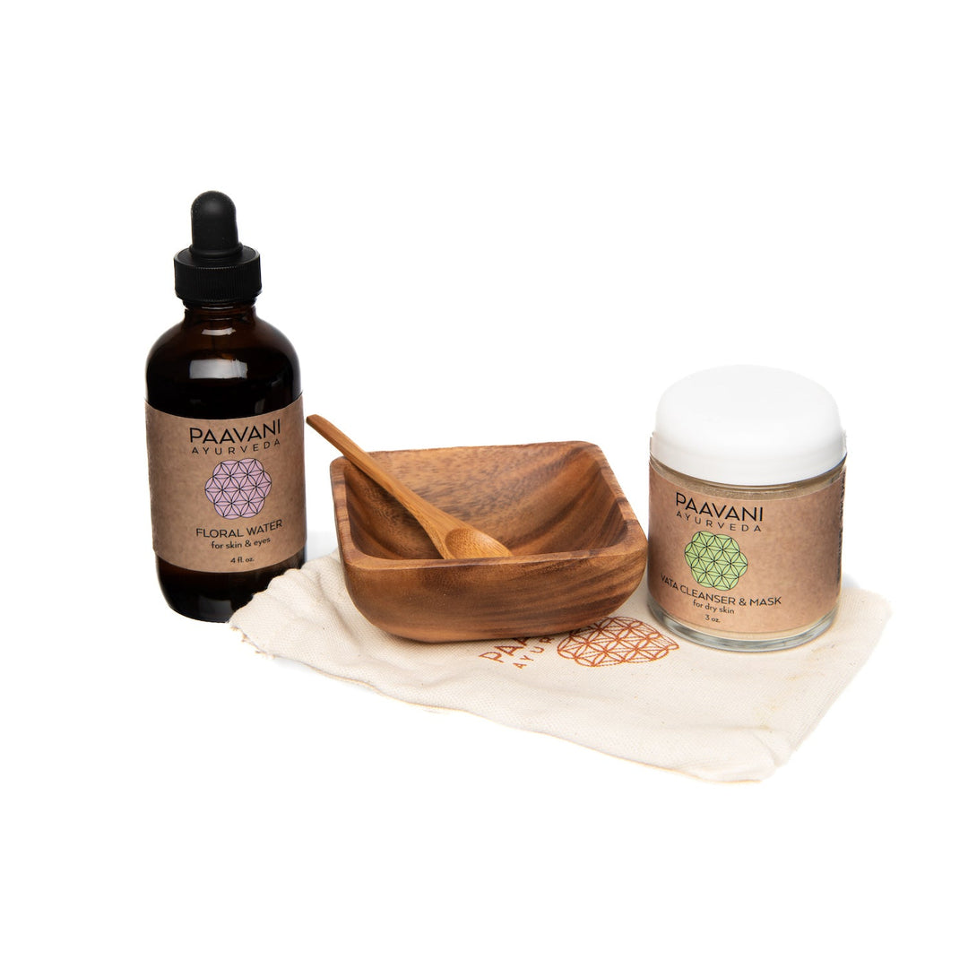 Cleanser and mask ritual kit with skincare products in white and green packaging on a wooden surface.