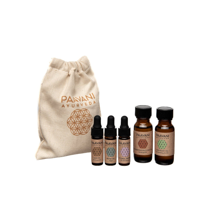 Dinacharya Ayurvedic self-care kit with herbal oils, tools, and a guide.
