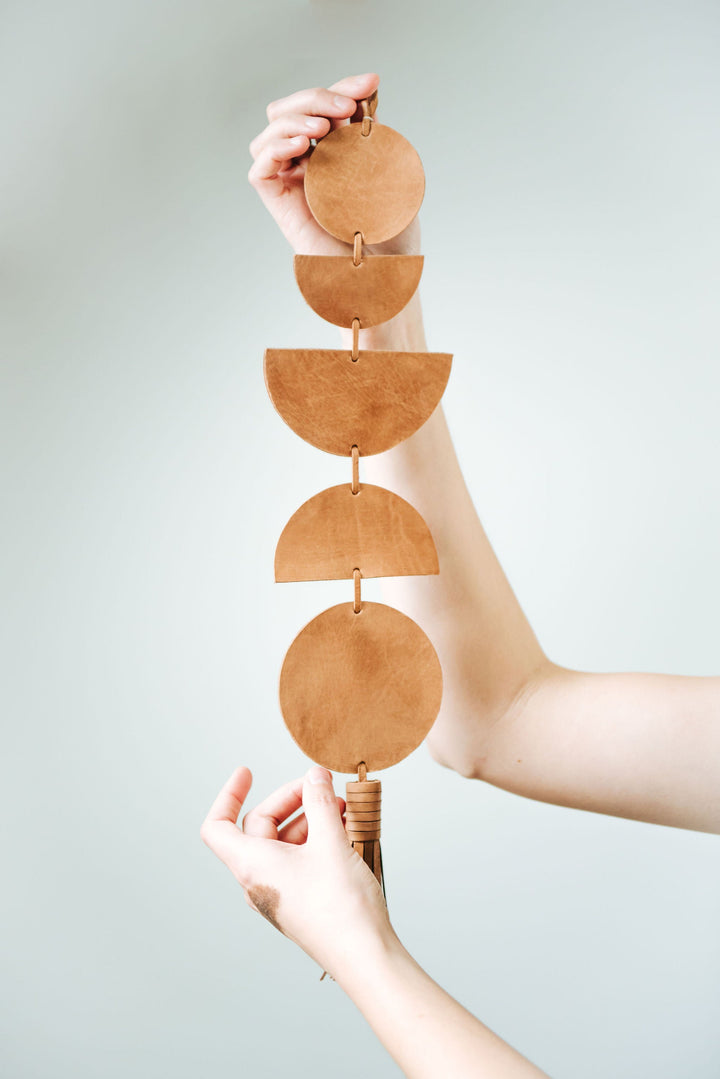 Handcrafted leather Luna moon-phase wall hanging with detailed phases.
