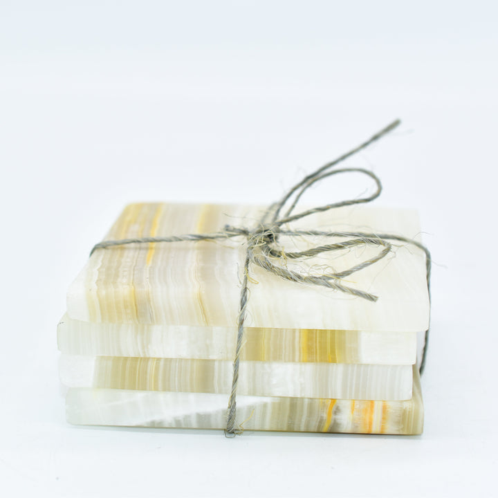 Set of four square onyx stone coasters with a smooth polished surface.