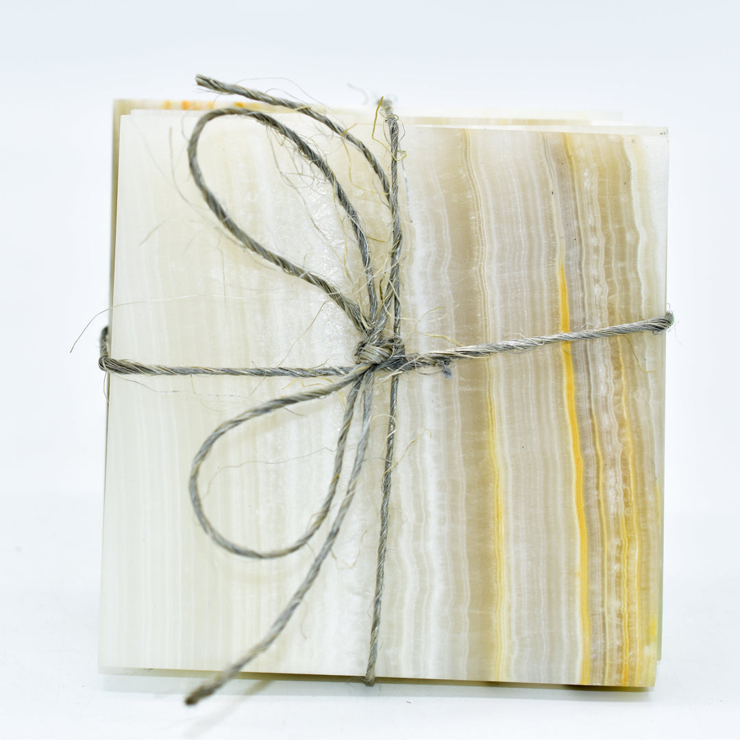Four polished onyx coasters with smooth edges, 3.75 inches square.