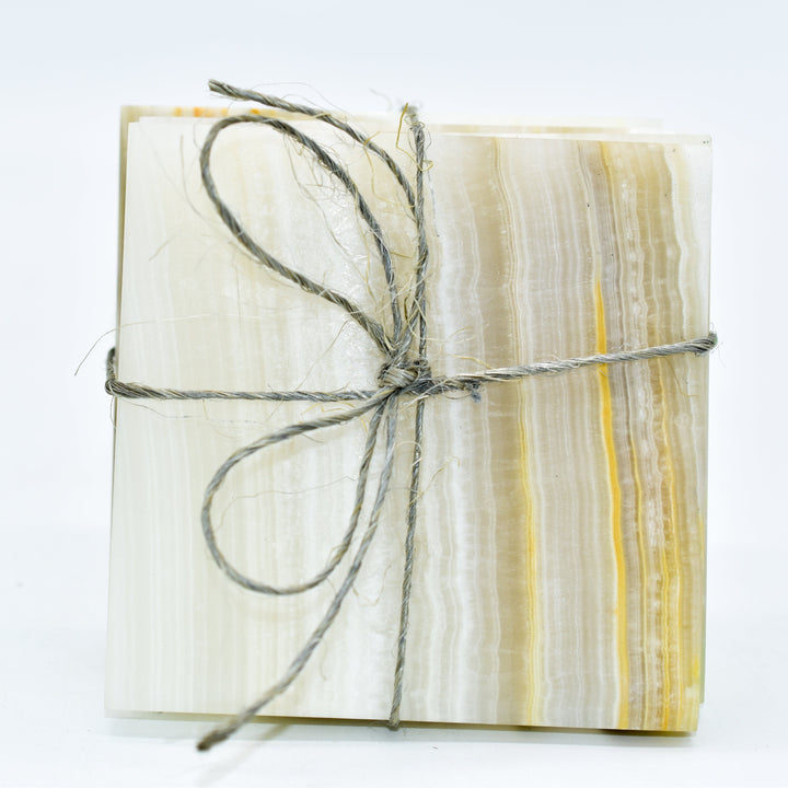 Four polished onyx coasters with smooth edges, 3.75 inches square.