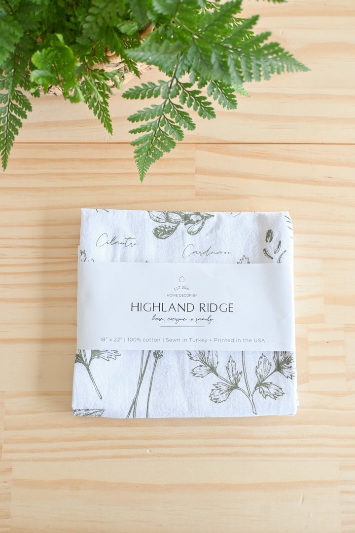 Kitchen herbs tea towel with detailed watercolor herb illustrations.