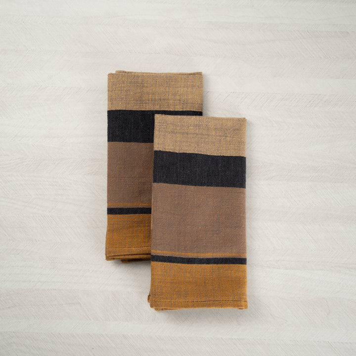 Pair of mocha color block cotton dinner napkins, folded