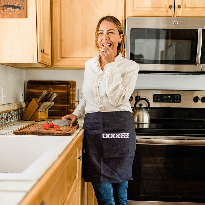 Person wearing a navy tatreez waist apron while cooking.