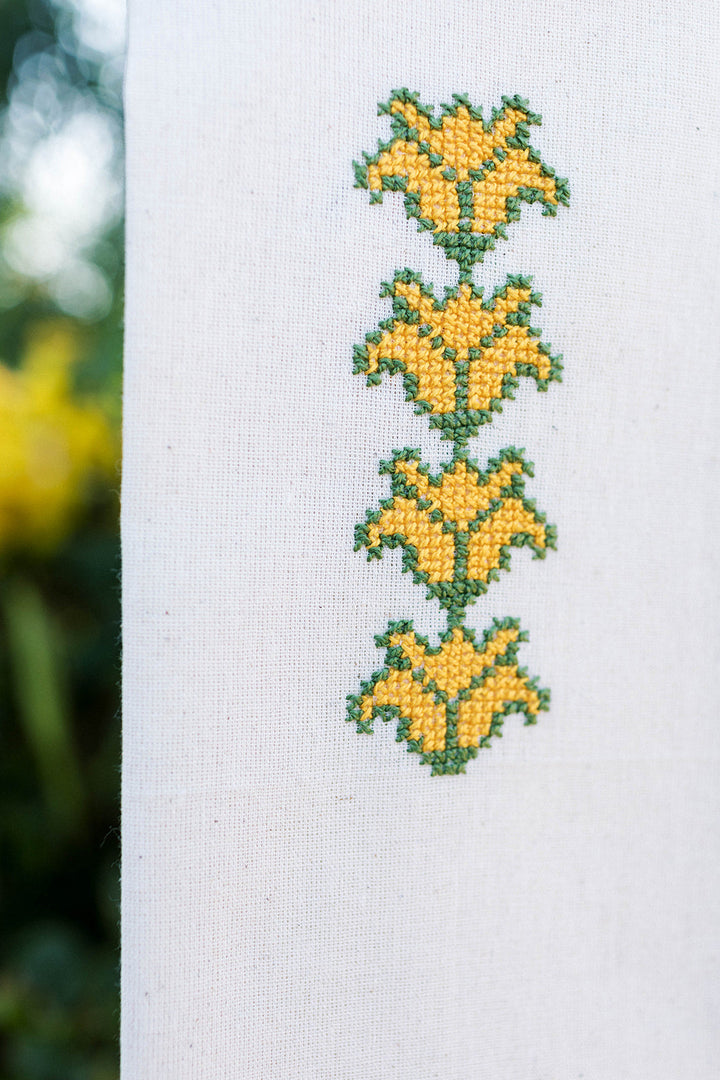 Close-up of the Cauliflower tatreez embroidery in yellow and green hand cross-stitch.