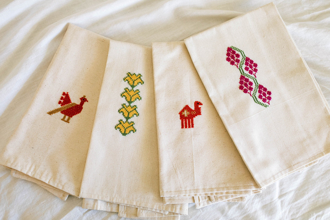 Close-up of the Grapes tatreez embroidery in magenta-pink and green hand cross-stitch.