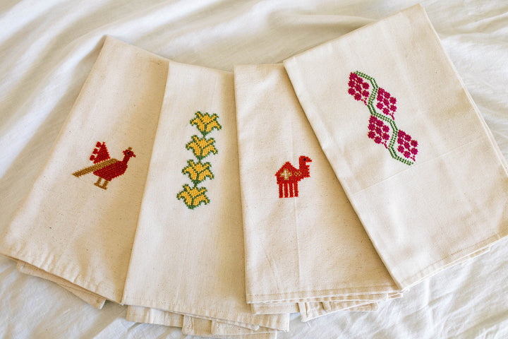 Close-up of the Grapes tatreez embroidery in magenta-pink and green hand cross-stitch.