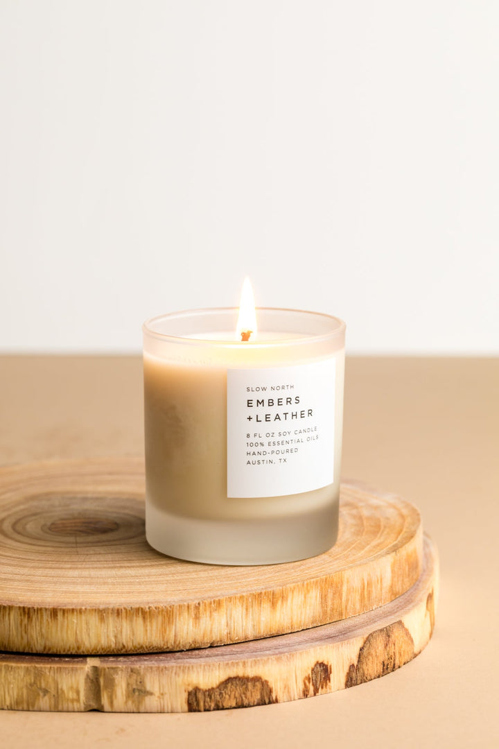 Embers &amp; Leather signature candle with leather accents in a glass jar.