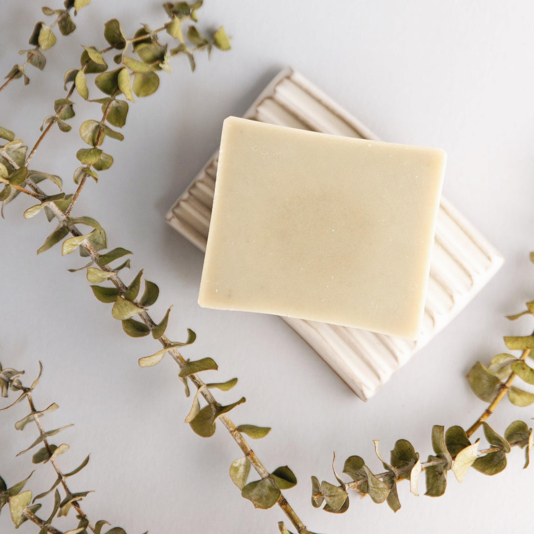 White and purple eucalyptus-lavender soap bar photographed on a neutral background.