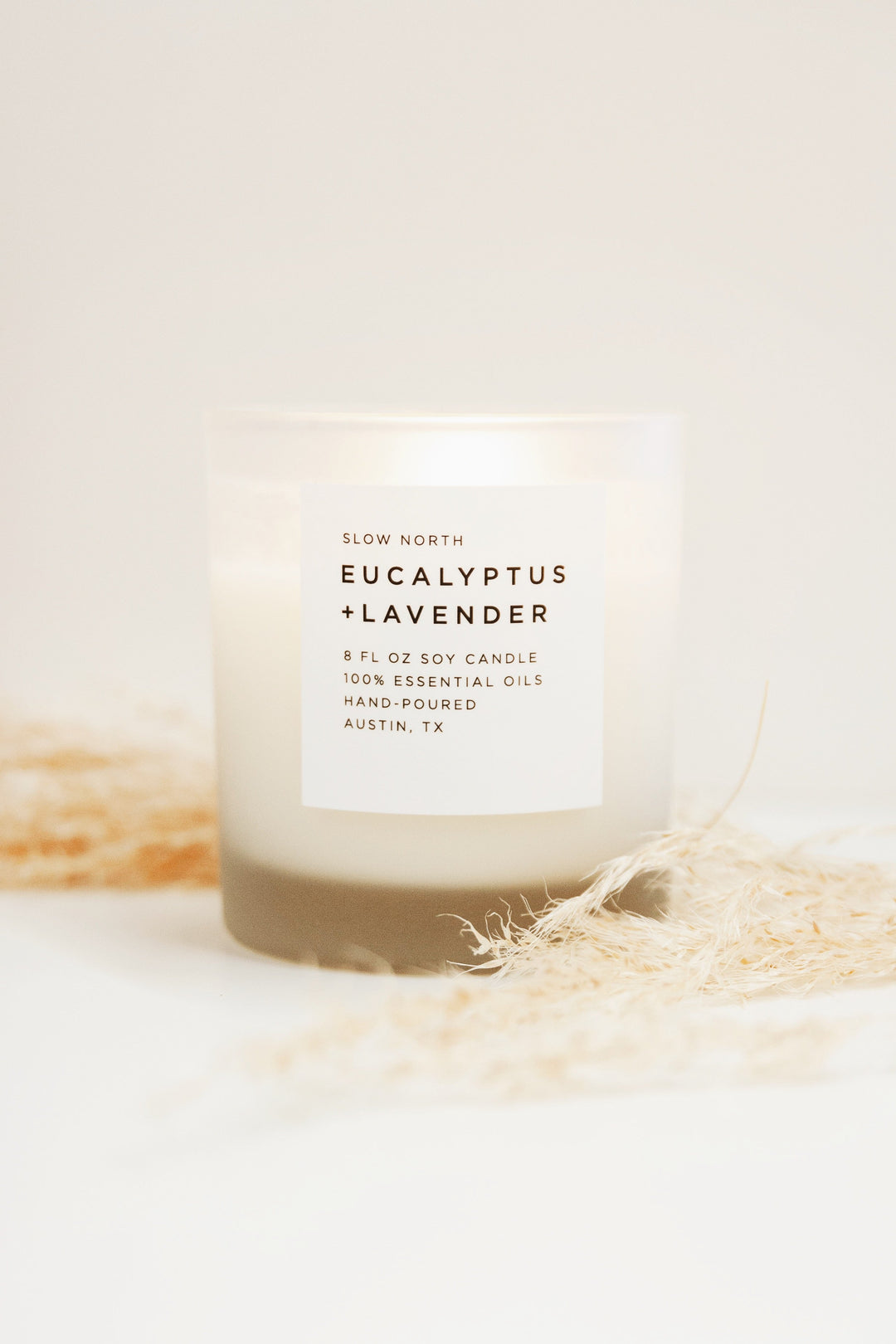 8 oz eucalyptus and lavender candle in a glass jar with a lit wick.