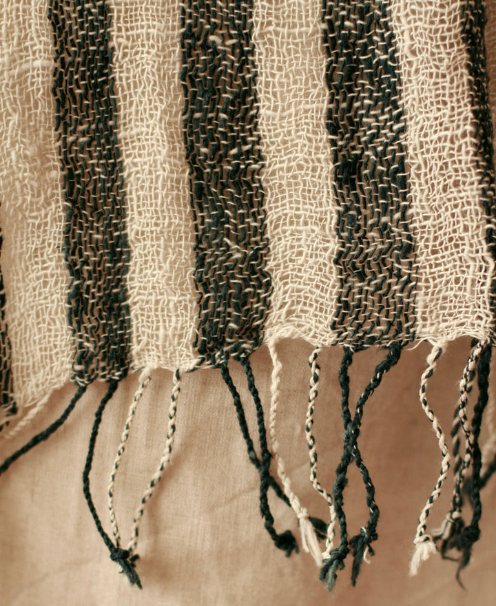 Hand-loomed black cotton scarf featuring an intricate woven pattern and soft texture.