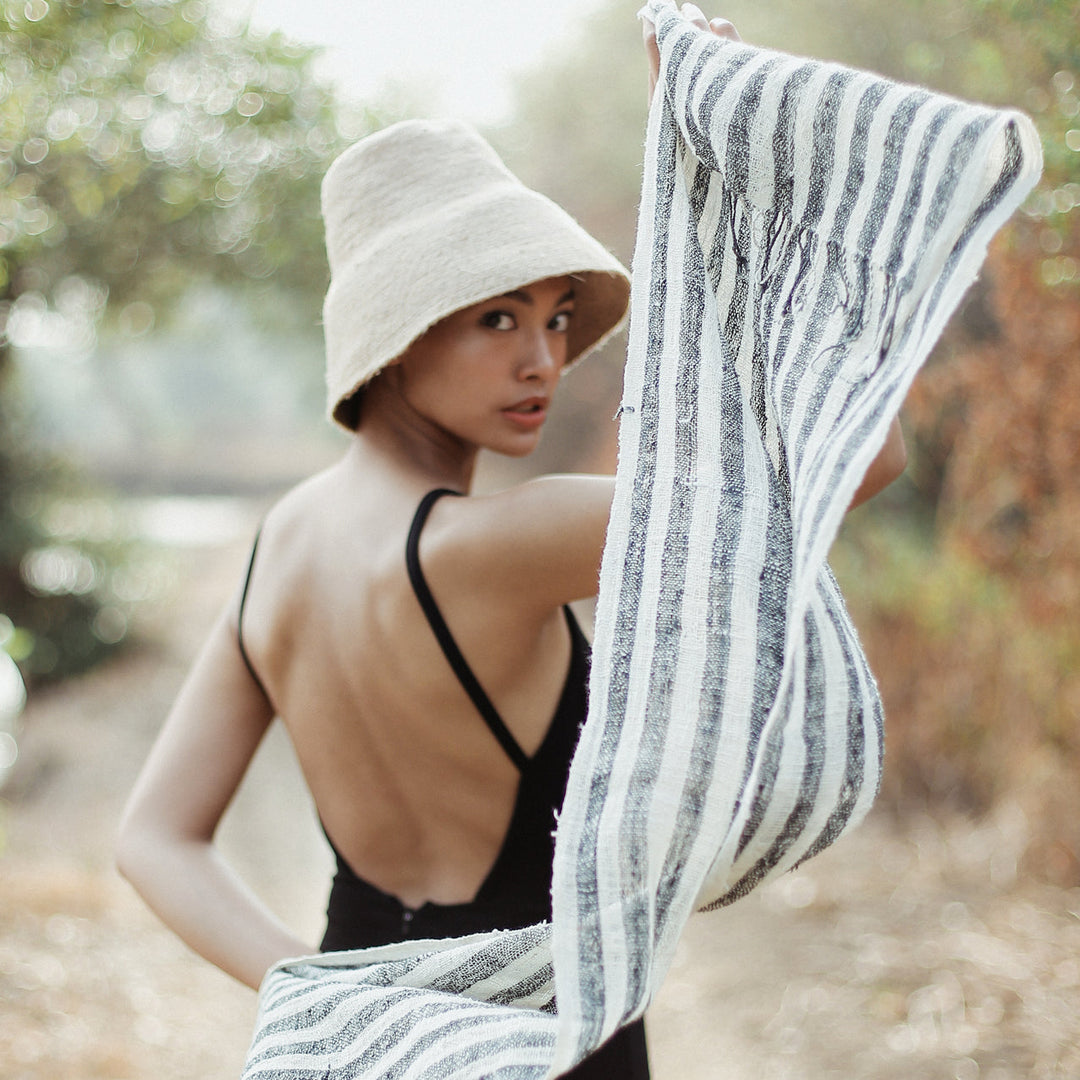 Hand-loomed black cotton scarf featuring intricate weaving and soft, breathable fabric.