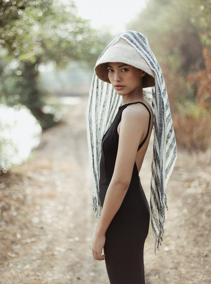 Black hand-loomed cotton scarf featuring intricate weaving and soft texture, styled as a versatile accessory.