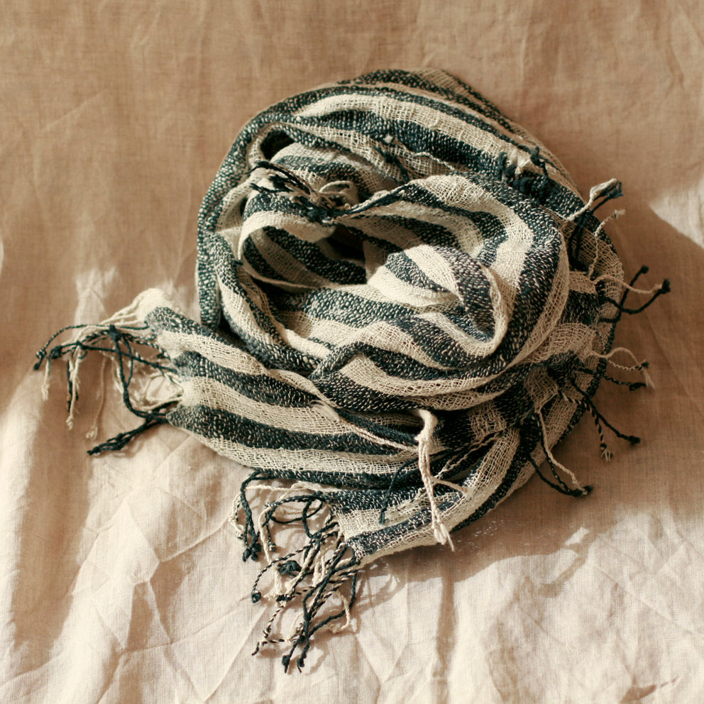 Hand-loomed black cotton scarf featuring intricate woven patterns and soft texture, perfect for versatile wear.
