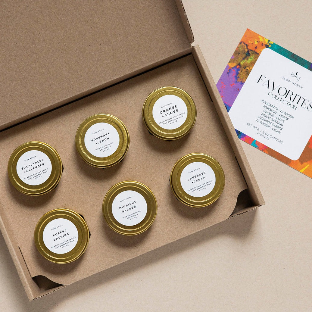 Six mini tin candles from the Favorites Collection with colorful packaging and various scents.