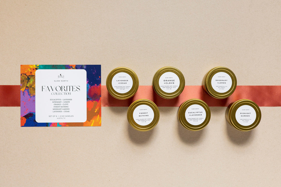 Six mini tin candles from the Favorites Collection with colorful packaging.