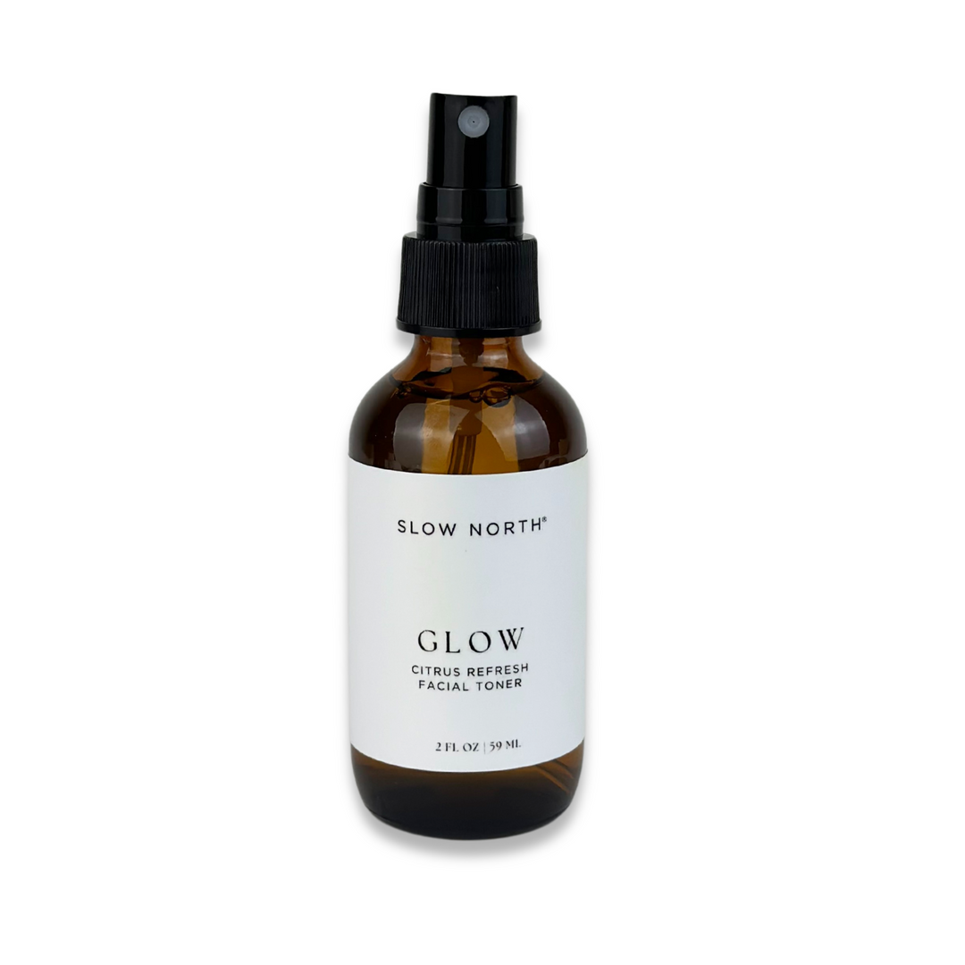Glow Citrus Refresh facial toner in a clear bottle with bright citrus orange liquid.