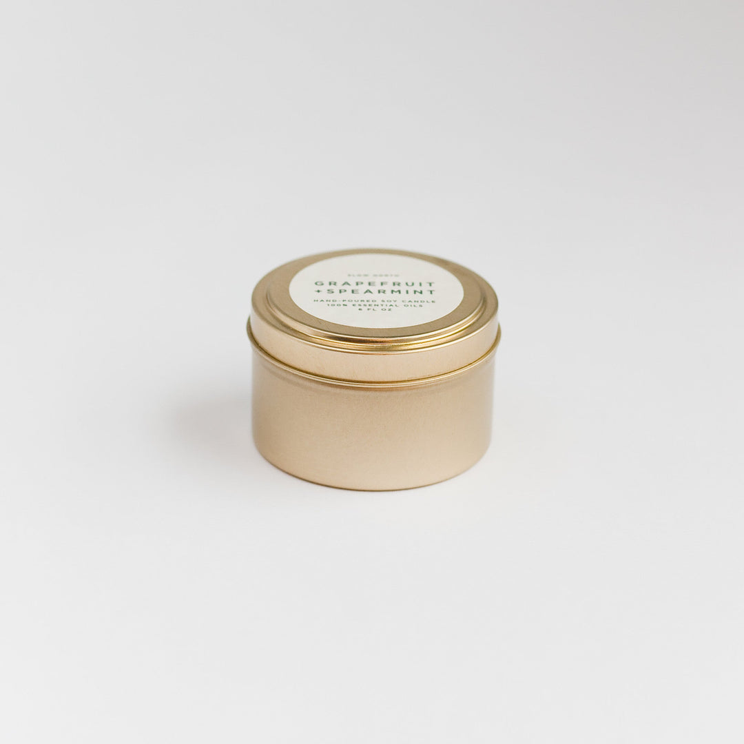 Grapefruit spearmint candle in a compact travel tin with white wick.