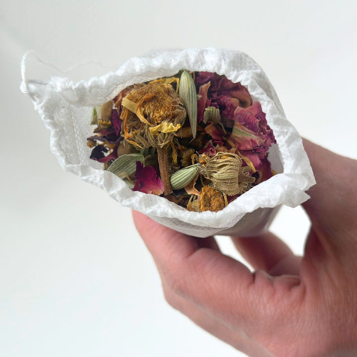 Herbal bath tea single soak in a clear jar with dried botanicals.