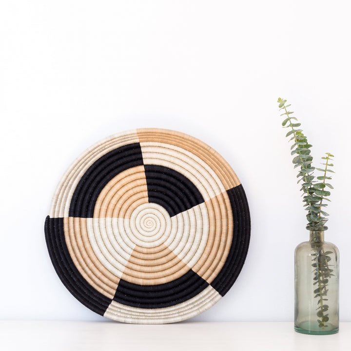 Staccato woven bowls displayed as wall decor in black and tea-toned sisal.