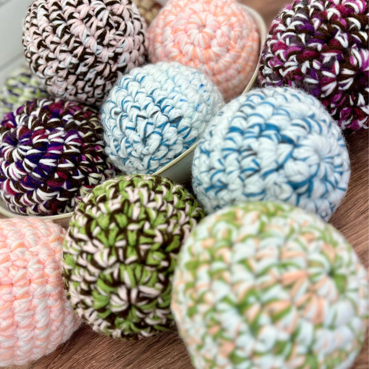 Handmade dryer ball from repurposed materials, on a laundry surface.