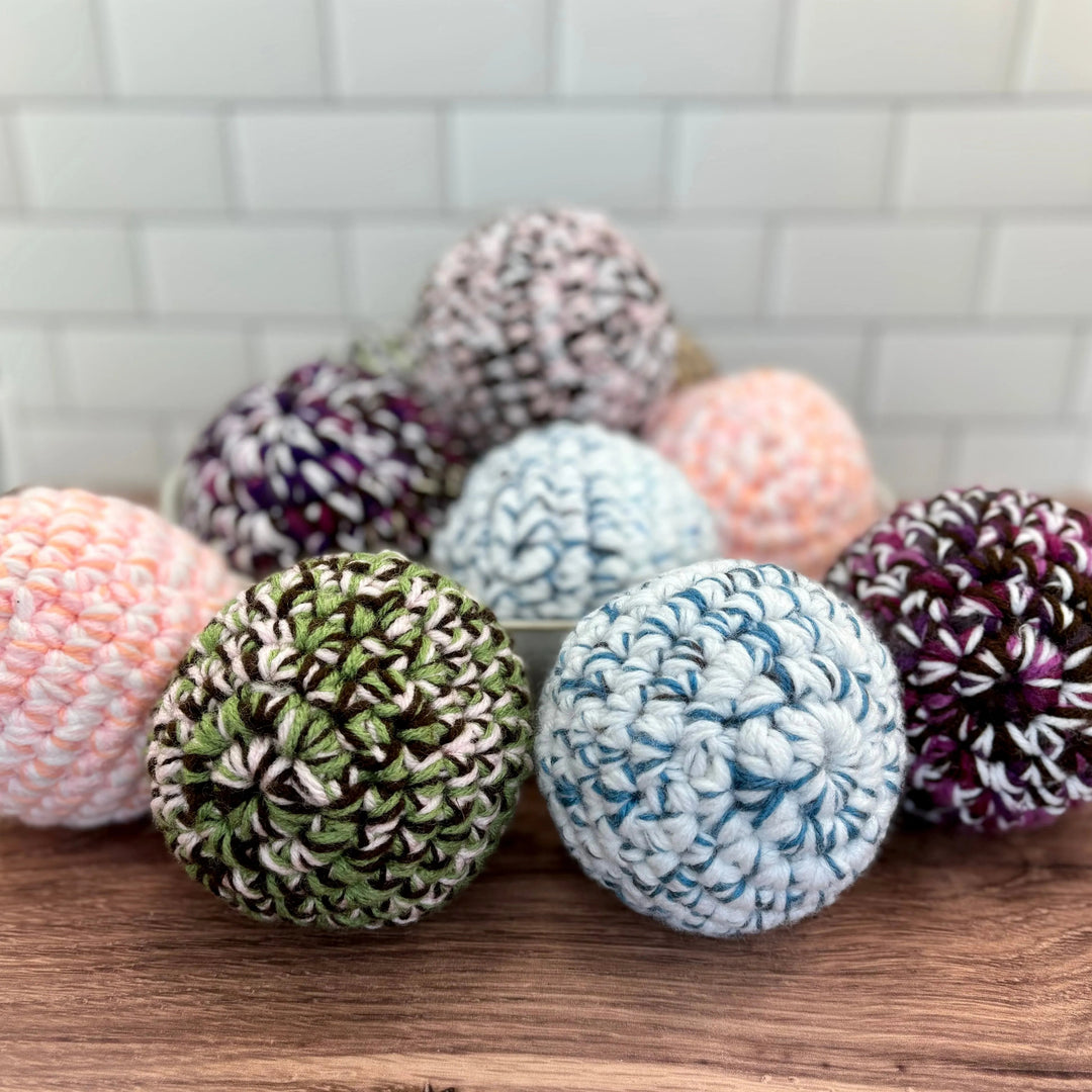 Handmade upcycled-fabric dryer ball with a soft, textured surface.