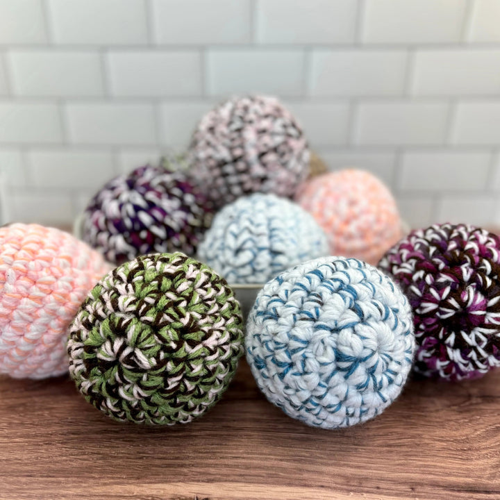 Handmade upcycled-fabric dryer ball with a soft, textured surface.