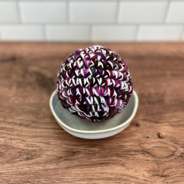 Handmade dryer ball from upcycled yarn and fabric, used in the dryer.
