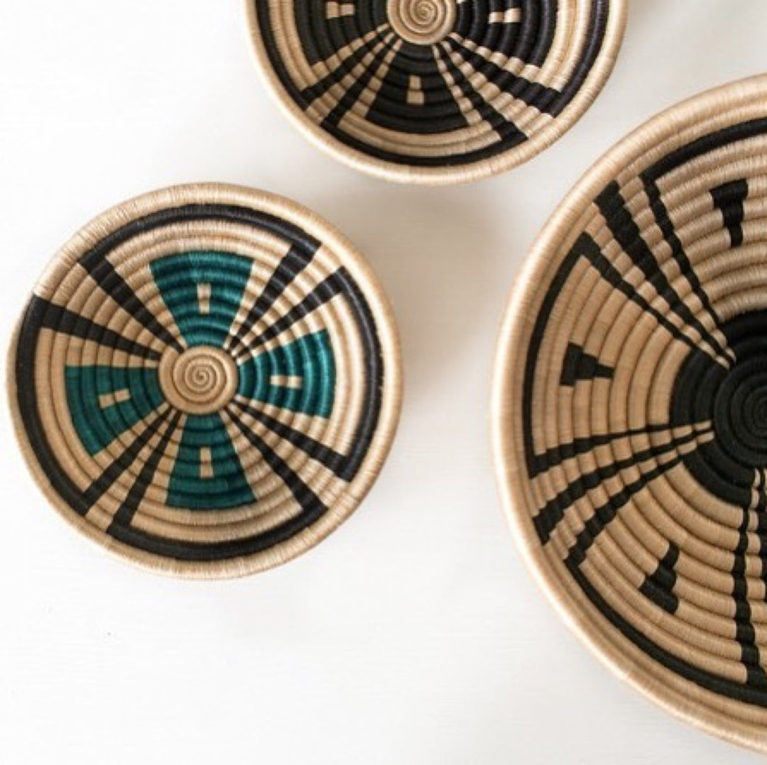 Akazi woven bowls in tea-toned sisal with a fine line-burst pinwheel pattern.
